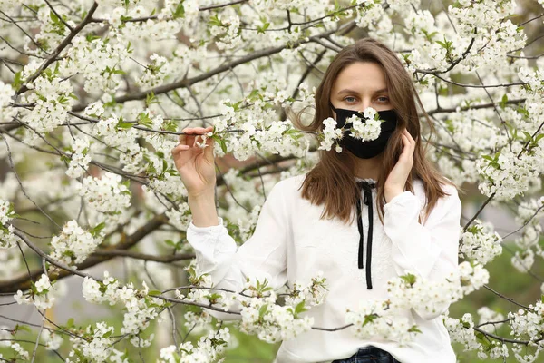 Uma Menina Alérgica Flores Uma Máscara Médica Toca Ramo Cerejeira — Fotografia de Stock