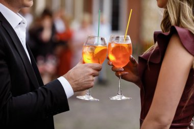 Kokteyl içen genç bir çift. Kokteyl içen iki kişinin elleri. Alkollü kokteyl. meşrubat.