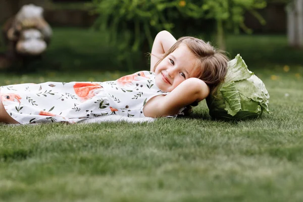 可爱的小女孩笑着和卷心菜躺在草地上 母亲节 为人父母 童年概念 — 图库照片