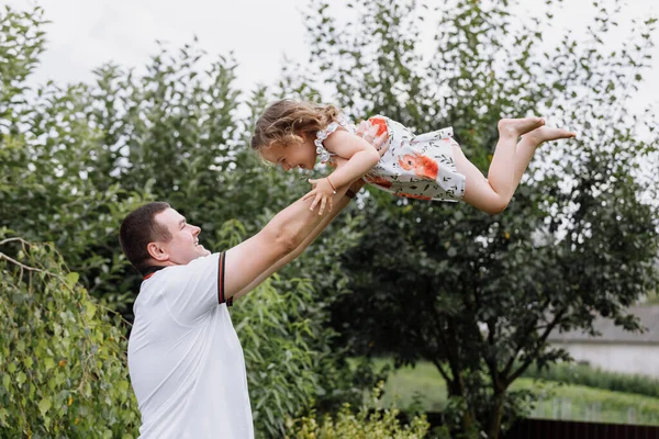 Genç bir baba, yaz günü kızını gökyüzüne fırlatıyor. Babalar Günü.