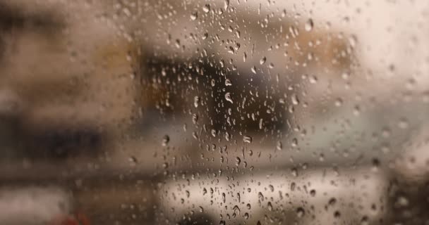 Lluvia fuera de la ventana. gotas de lluvia corren por el cristal. Las gotas de lluvia en el vaso. Concéntrate en las gotas de lluvia que caen por el cristal. fondo de otoño al aire libre. Fondo abstracto de otoño. Borrosa.. — Vídeo de stock