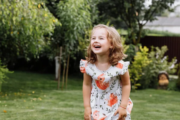 Pequena menina feliz se divertindo no parque de verão verde. Chuldhood feliz — Fotografia de Stock