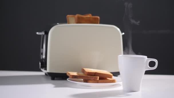 커피 한 잔. 커피나 차. 흰색 컵에 증기로 뜨거운 음료를 넣는다. 토스트를 준비 해 놓고. 선택적 초점 — 비디오