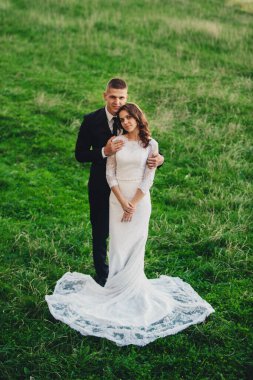 Gelin ve damat bir tepede duruyorlar. Sarıl bana. düğün sahneleme.