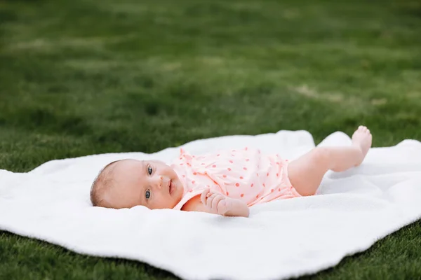Новорожденная Девочка Траве Парке Лежит Белом Одеяле Смотрит Вокруг Селективный — стоковое фото