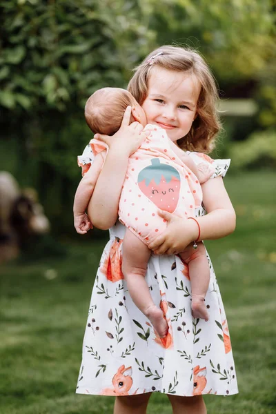 Pequeña Linda Chica Está Sosteniendo Una Hermana Recién Nacida Sus —  Fotos de Stock