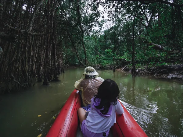 两个民族的雨衣在蛇丛林里玩独木舟 — 图库照片
