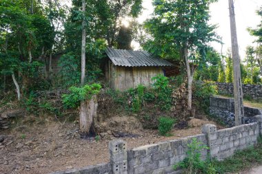 Güneydoğu Asya 'da teneke çatılı ve yıpranmış beton blok duvarlı kırsal çit yerleşkesi.