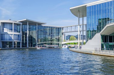 Berlin, Almanya - 22 Nisan 2018: Nehir Spree birçok turist tekne ve onun yaya köprüsü Mierscheid-Steg Marie-Elisabeth-Lueders House ile soldan sağa doğru Parlamentosu yeni binalar Paul-Loebe House bağlanma