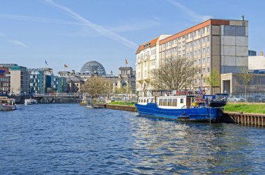 Berlin, Almanya - 22 Nisan 2018: Nehir Spree onun banka Schiffbauerdamm, turist tekneleri, köprünün Marschallbruecke ve Reichstag arka planda Bina Parlamento ile