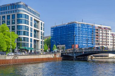 Berlin, Almanya - 22 Nisan 2018: Spree Nehri ve onun banka Schiffbauerdamm, modern Murphys Irish pub, Weidendammer köprü tramvay ile ve Riverside Hotel imar altında bina