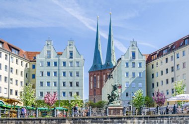 Berlin, Almanya - 22 Nisan 2018: Nikolaiviertel (Nicholas Quarter) Alt-Berlin Spree Nikolaikirsche (Saint Nicholas Kilisesi), restore edilmiş tarihi evleriyle dan görüldüğü gibi Berlin'in en eski kilise, skulpture St.George, 