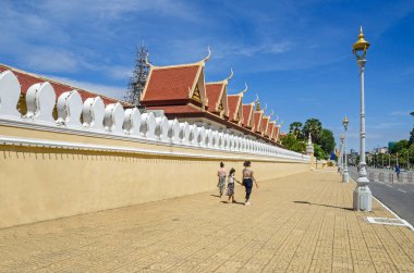 Phnom Penh, Kamboçya - 8 Nisan 2018: Klasik Khmer çatılar ve turistler bu ünlü cazibe ile Kraliyet Sarayı dış duvarına kamu açık sabah