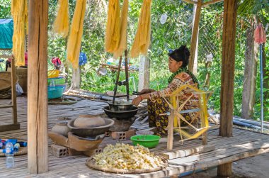 Chong Koh, Kamboçya - 9 Nisan 2018: İpek-weaver uzak küçük bir köyde Chong silworm ipekten edinme turistlere gösterilen Koh Mekong Nehri kıyısında Koza
