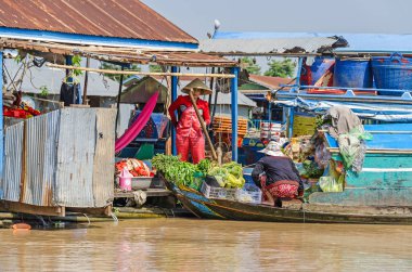Siem Reap, Kamboçya - 11 Nisan 2018: Siem Reap Tonle Sap Gölü çevresinde yüzen köylerinden invaziv su sümbül ahşap evler ve tekneler ve yiyecek ve onların tekneler mallarını satan kadınlar ile kaplı