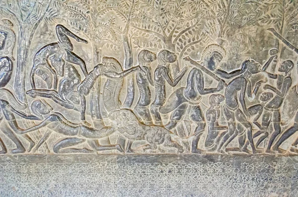吴哥窟的一个画廊的墙壁与它的线形排列的石雕 装饰着浮雕显示大型场景主要描绘情节从印度教史诗的罗摩衍那和罗多 — 图库照片