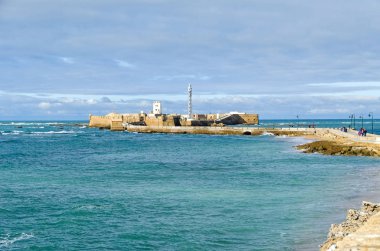 Cadiz, İspanya - 2 Kasım 2018: Castle San Sebastan, küçük bir ada beach La Caleta görüldüğü gibi ana şehir, deniz feneri ve ziyaretçi ile ayrılmış bir kale