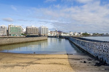 Arrecife, İspanya - 5 Kasım 2018: Waterfront şehrin ve popüler sahil mesire Atlantik kıyısında Avenida Coll ve Avenida Olof Palme San Gines Katolik Kilisesi'nin Kulesi ve kale kapıları (Puente de Las ile Köprü