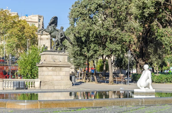 Barcelona, İspanya - 10 Kasım 2018: Neoklasik bir atlı heykeli, bir kadın ve çok sayıda güvercin Josep Llimona'nın heykeli Placa de Catalunya (Katalonya Meydanı)