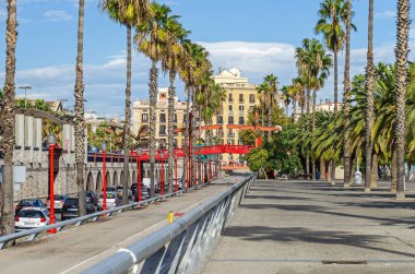 Barcelona, İspanya - 10 Kasım 2018: Passeig de Colom, yöne doğru Pas Sota tygrstyle ile ilgilenen yol üzerinde kırmızı bir köprü ile palmiye ağaçları ile kaplı geniş bir cadde