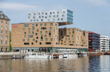 Berlin, Almanya - 22 Nisan 2018: Otel nhow - Europe ilk müzik hotel bir Nehri'nin çılgınlığı Osthafen içinde onun Cafe ruhu ile ve güneş üzerinde yaratıcı medya bölgesinin merkezinde elektrikli tekneler powered