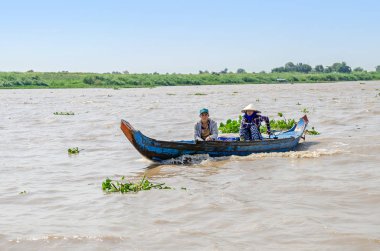 Uzun kuyruk Mekong tekne Kamboçya bir aile manoevring ile bu Mekong Nehri kıyısında