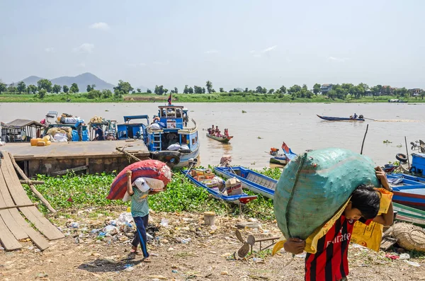 Cargadores que transportan sacos pesados descargando el buque de carga en la orilla del río Mekong — Foto de Stock