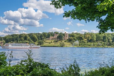 Potsdam, Almanya - 12 Temmuz 2020: Tiefer See (Tiefe Gölü) with the Babelsberg Palace and eponymous park design by Peter Joseph Lenne and the turist botu Charlottenhof