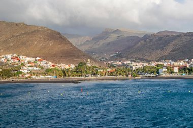 Barranco de la Villa vadisinde yer alan San Sebastian de la Gomera yolcu gemisi terminalinden kumsalı, Avenida de los Descubridores bulvarı ve dağları ile görüldü.