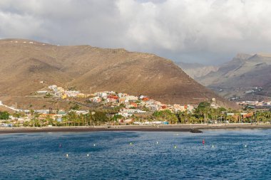 Barranco de la Villa vadisinde yer alan San Sebastian de la Gomera yolcu gemisi terminalinden kumsalı, Avenida de los Descubridores bulvarı ve dağları ile görüldü.