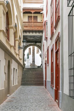 Santa Cruz de la Palma, İspanya - 12 Kasım 2019: Manuel Hernandez Diaz 'ın anıtıyla Plaza de Espana' da tipik dar geçitlerden birine bakın