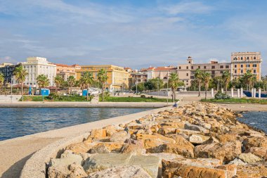 Civitavecchia, İtalya - 28 Mayıs 2016: Roma Limanı olarak da bilinen büyük bir gemi ve feribot limanı olan Civitavecchia manzarası, bir plaj ve renkli binalarıyla Via Aurelia kıyı caddesini gösteriyor.