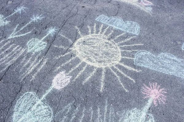 Sun. Sky. Flowers. Drawings chalk on the asphalt.