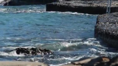 Sıcak denizin dalgaları kıyıda bir sessiz güneşli gün, su sıçramasına yendi. yakın çekim