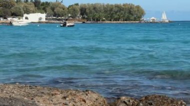 Deniz kenarındaki güzel sörf, su sıçramasına bir Yelkenli Yat içinde belgili tanımlık geçmiş, tatil ile güzel küçük koy