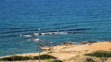 Otel penceresinden deniz manzarası, açık mavi deniz, açık esinti, kumlu plaj.