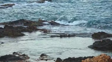 Kayalık kıyı üzerinde taze bir esinti sırasında deniz sörf, deniz koyu tonları, yüksek kontrast, hareket bir sürü