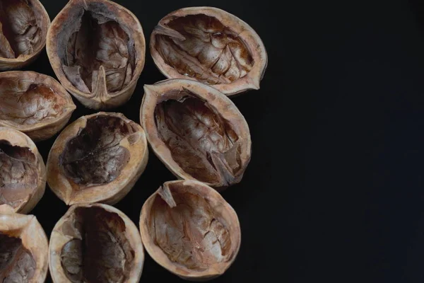 Doğal ceviz kabukları kopya alanı ile koyu arka plan çekirdekleri. Üstte görüntü.