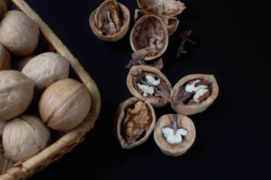 Fotokopi alanı, fındık kıracağı, parlak renkler, yüksek kontrastlı koyu bir arka planda tam ve doğranmış ceviz..