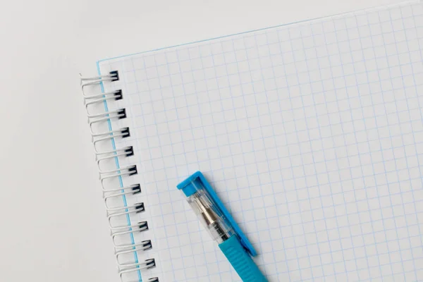 Notebook e uma caneta colorida em um fundo branco com espaço de cópia — Fotografia de Stock