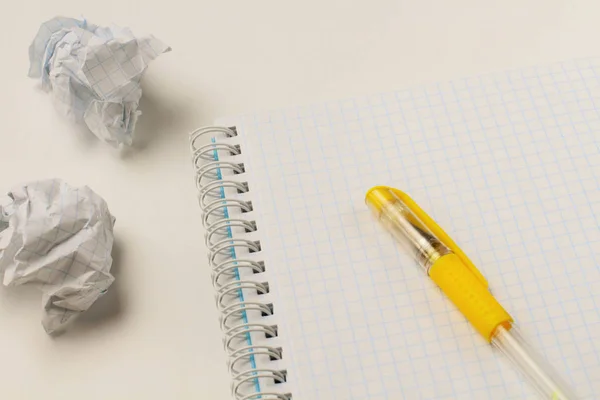 A notepad with torn pages and a colored pen on a white backgroun