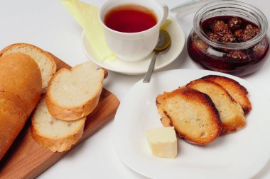 Basit bir tatlı kahvaltı için ayarlayın, tost baget, çay, tereyağı, çam kozalağı reçel. Parlak renkler, yüksek kontrast, beyaz arka plan.