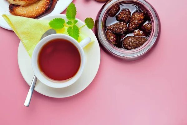 Bir imza, çay, kızarmış ekmek, reçel, yüksek kontrast, parlak renkler, üst görünüm için bir yer ile pembe bir arka plan üzerinde basit bir tatlı kahvaltı için ayarlayın.
