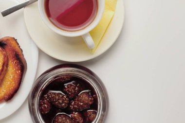 Basit bir tatlı kahvaltı için ayarlayın, tost baget, çay, tereyağı, çam kozalağı reçel. Parlak renkler, yüksek kontrast, beyaz arka plan.