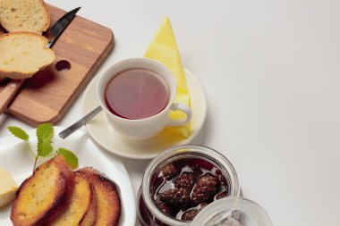 Basit bir tatlı kahvaltı için ayarlayın, kızarmış ekmek, çay, reçel, beyaz bir arka plan üzerinde. Metin için yer.