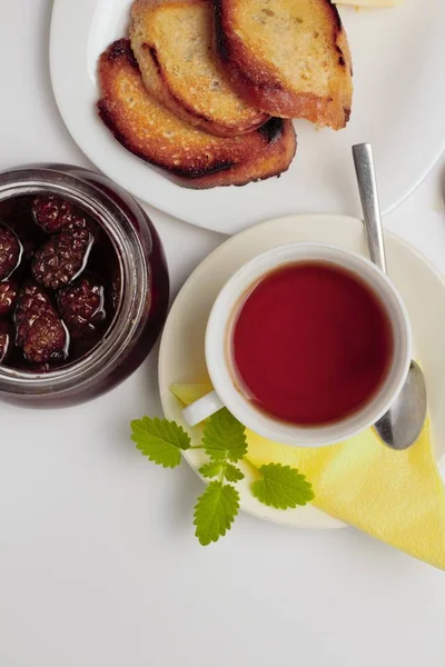 Basit bir tatlı kahvaltı için ayarlayın, kızarmış ekmek, çay, reçel, beyaz bir arka plan üzerinde. Metin için yer.