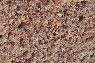 Bir arka plan olarak iyi pişmiş malt ekmek yüzeyini kesin. Doğal yapı ve renk, yüksek kontrast.