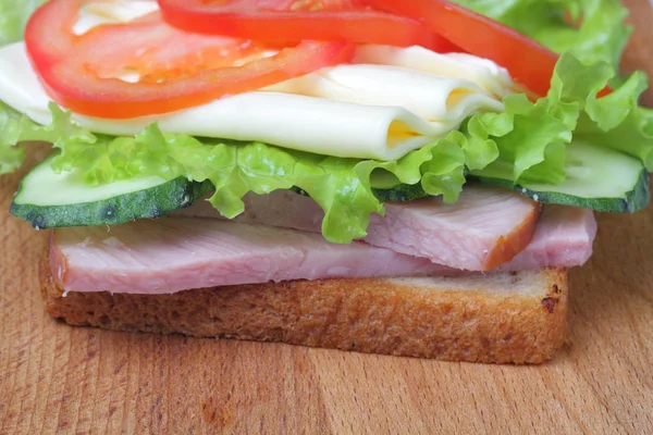 Sandwich Mit Schinken Salat Scheiben Käse Tomaten Auf Einem Schneidebrett — Stockfoto