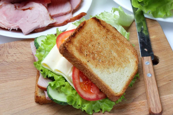 Sandwich Con Jamón Lechuga Rebanadas Queso Tomates Una Tabla Cortar — Foto de Stock