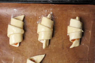 Kızartma için bir fırın tepsisine ev yapımı kruvasan için hazırlıklar.